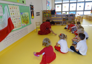 10 Dzieci siedzą w półkolu, pani Ewa rozkłada karteczki na podłodze